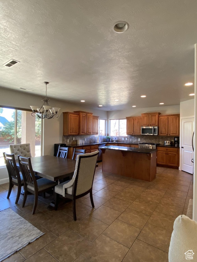 1918 S Mojave Dr, Washington, UT 84780 - tiled dining area featuring a textured ceiling, a wealth of natural light, and a chandelier