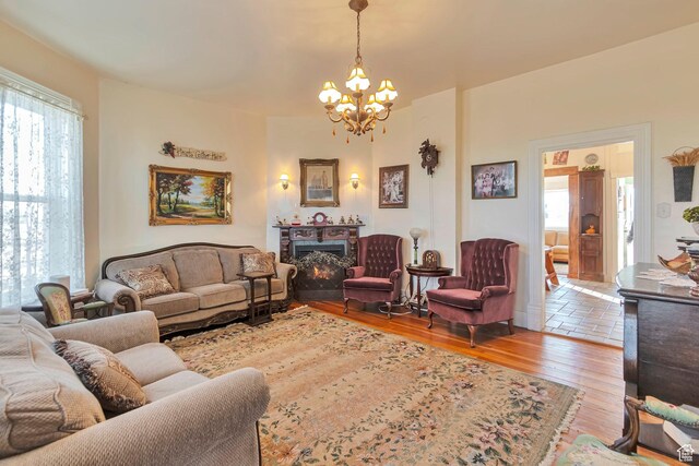 320 S 800 W, Lewiston, UT 84320 - living room featuring wood finished floors, a lit fireplace, and an inviting chandelier