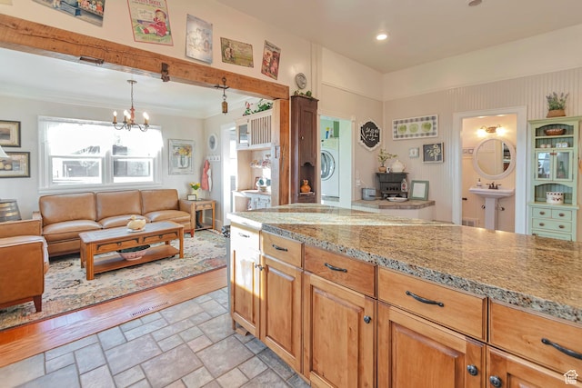 320 S 800 W, Lewiston, UT 84320 - kitchen with a chandelier, stone finish flooring, light stone countertops, ornamental molding, and washer / dryer