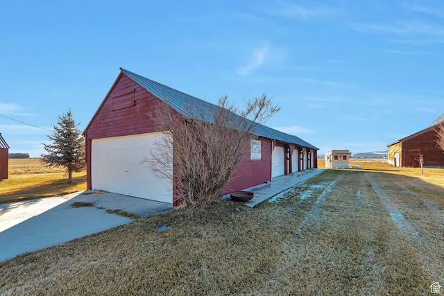 320 S 800 W, Lewiston, UT 84320 - view of side of property with metal roof, a detached garage, an outbuilding, and concrete driveway