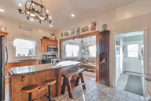 320 S 800 W, Lewiston, UT 84320 - kitchen featuring tasteful backsplash, a sink, a breakfast bar, an inviting chandelier, and stainless steel appliances