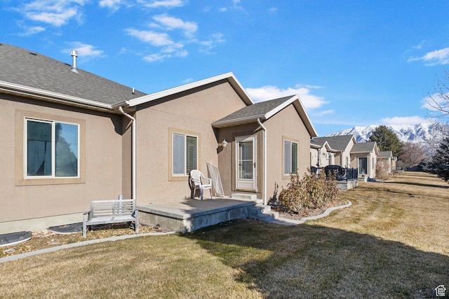 back of property with a lawn and a patio