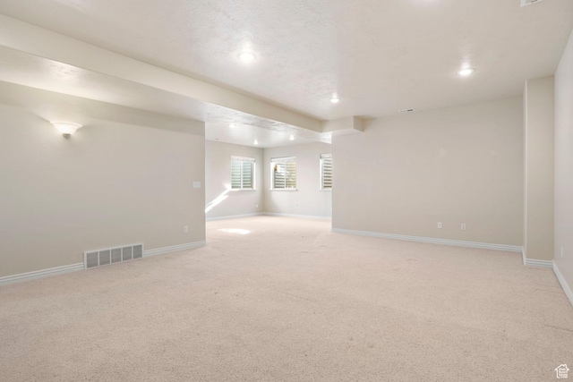 unfurnished room featuring light carpet and a textured ceiling