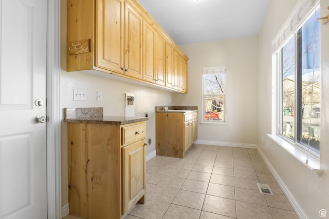 washroom with cabinets, sink, and light tile patterned flooring
