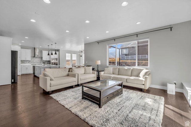 living room with sink, dark hardwood / wood-style flooring, and a chandelier