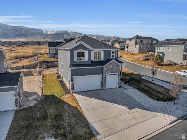 view of front of house with a front yard, a garage, and a mountain view