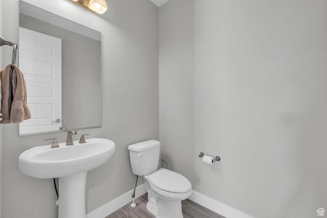bathroom featuring toilet and wood-type flooring