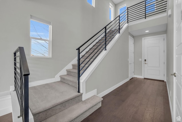 stairway featuring a high ceiling and hardwood / wood-style flooring