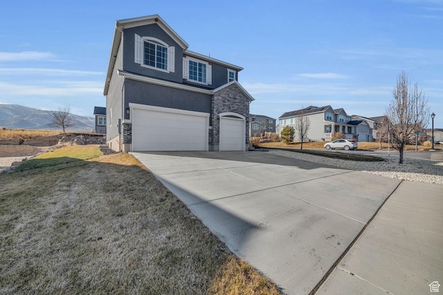 view of front of house with a front yard, a garage, and a mountain view