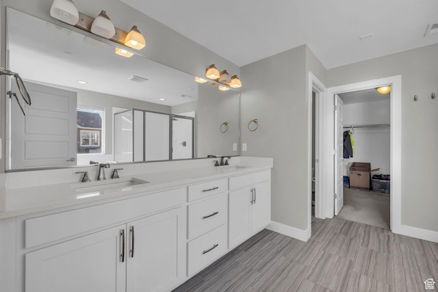 bathroom with a shower with door and vanity