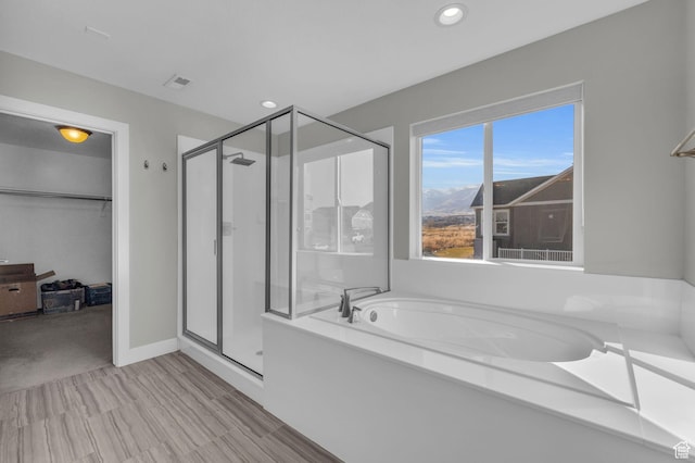bathroom featuring shower with separate bathtub