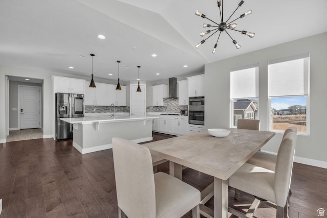 dining room with dark wood-type flooring, lofted ceiling, an inviting chandelier, and sink