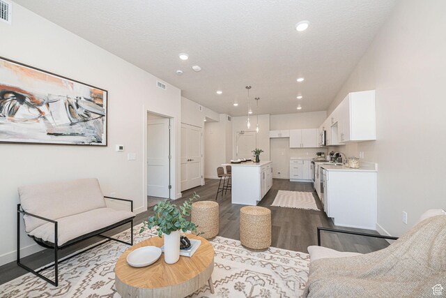 living room with a textured ceiling and hardwood / wood-style floors