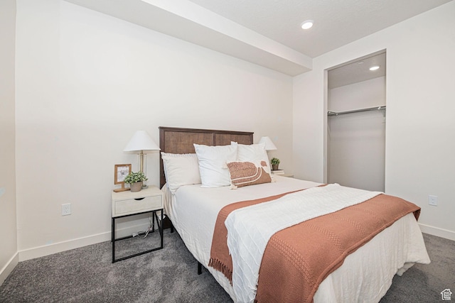 bedroom featuring a spacious closet, dark colored carpet, and a closet