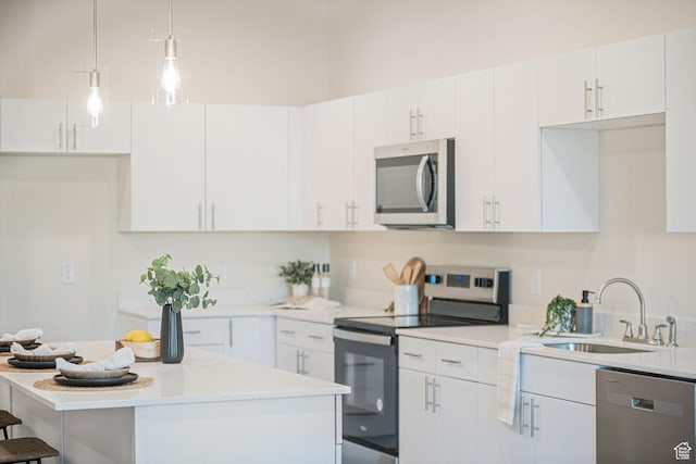 kitchen with white cabinetry, stainless steel appliances, decorative light fixtures, a kitchen island, and sink