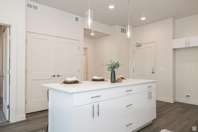 kitchen with dark hardwood / wood-style floors, pendant lighting, white cabinets, and a center island