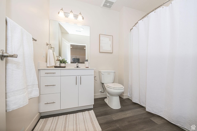 bathroom with hardwood / wood-style flooring, curtained shower, toilet, and vanity