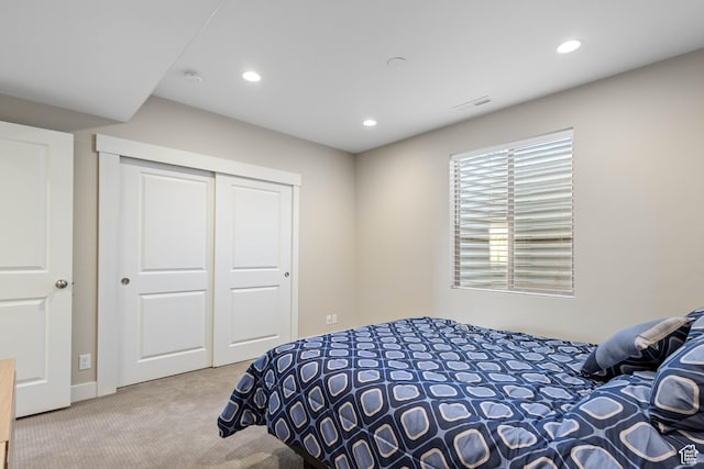 carpeted bedroom with visible vents, recessed lighting, and a closet