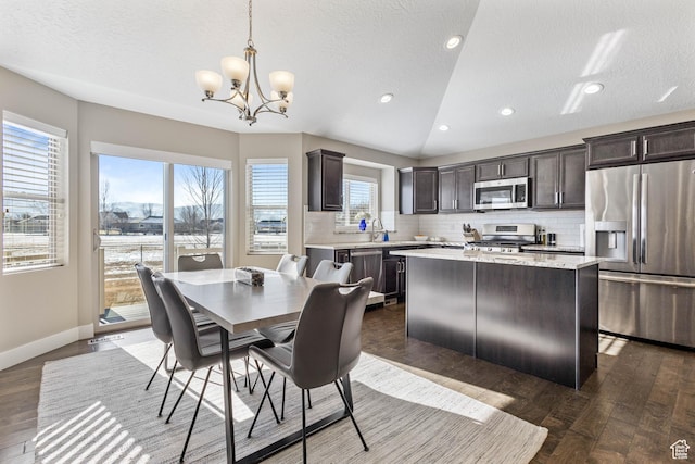 dining area with a chandelier, baseboards, a textured ceiling, and dark wood-style floors