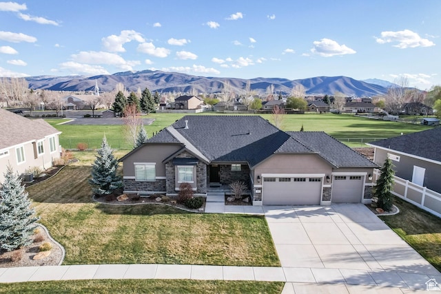 ranch-style house featuring fence, concrete driveway, an attached garage, stone siding, and a front yard