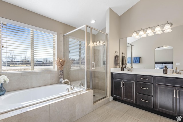 bathroom with a bath, a sink, double vanity, and a stall shower