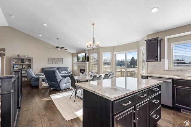 kitchen featuring dark wood finished floors, vaulted ceiling, recessed lighting, dishwasher, and a fireplace