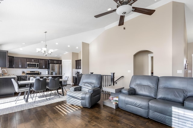 living room with arched walkways, recessed lighting, ceiling fan with notable chandelier, hardwood / wood-style floors, and high vaulted ceiling