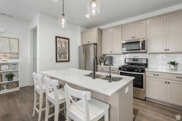 6671 W Skip Rock Rd, South Jordan, UT 84009 - kitchen with appliances with stainless steel finishes, backsplash, a kitchen island with sink, hanging light fixtures, and sink