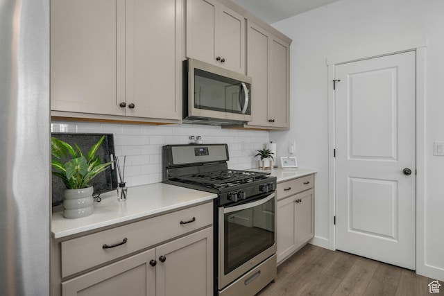 6671 W Skip Rock Rd, South Jordan, UT 84009 - kitchen with backsplash, light hardwood / wood-style flooring, and stainless steel appliances
