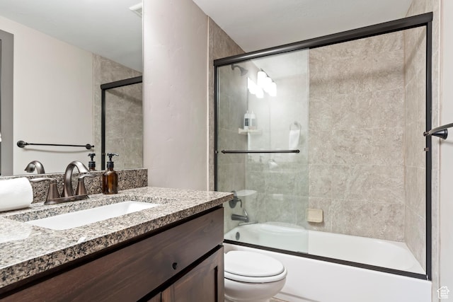 full bath featuring shower / bath combination with glass door, vanity, and toilet