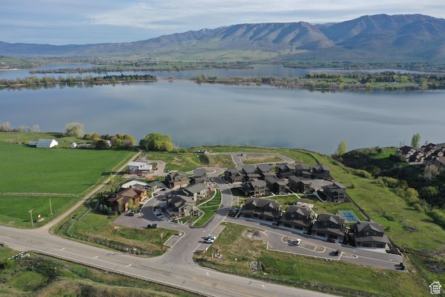 drone / aerial view with a water and mountain view and a residential view