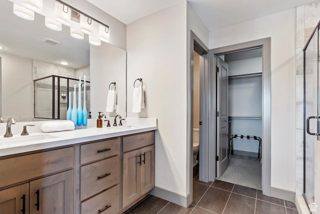 full bathroom featuring toilet, visible vents, a sink, and a stall shower