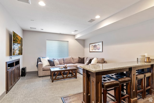 living room featuring light carpet, baseboards, visible vents, and recessed lighting