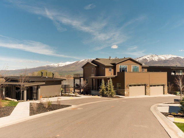 view of front facade featuring a mountain view, an attached garage, and stone siding