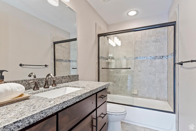 full bathroom featuring toilet, shower / bath combination with glass door, vanity, and tile patterned flooring