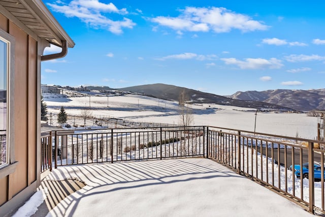 snow covered back of property with a mountain view