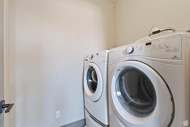 washroom with independent washer and dryer and laundry area