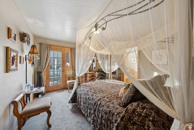 bedroom featuring access to exterior, a textured ceiling, and carpet