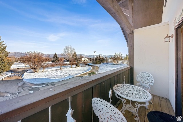 snow covered back of property featuring a mountain view