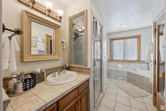 bathroom with vanity, tile patterned floors, a textured ceiling, and separate shower and tub