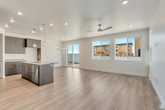 kitchen with light countertops, stainless steel dishwasher, dark brown cabinetry, and a sink