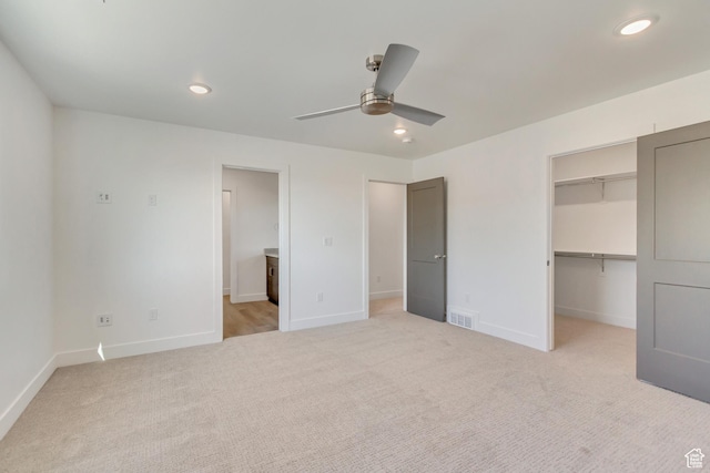 unfurnished bedroom with light carpet, baseboards, visible vents, a spacious closet, and recessed lighting
