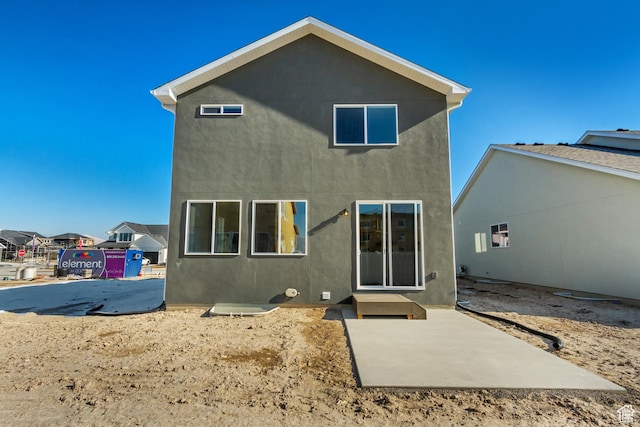 back of property with a patio area and stucco siding