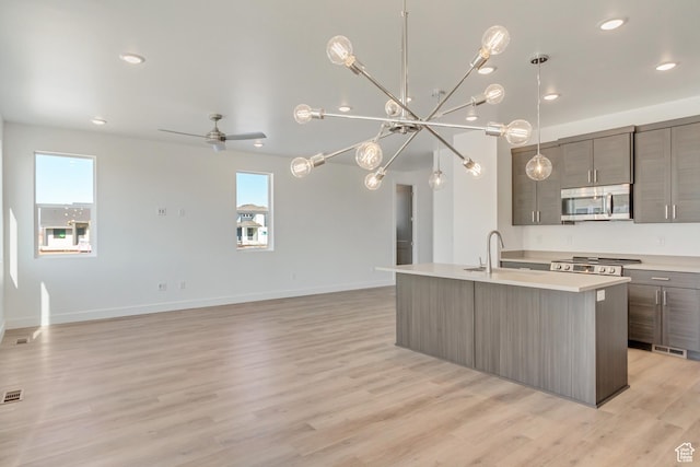 kitchen featuring modern cabinets, stainless steel microwave, a wealth of natural light, and a sink