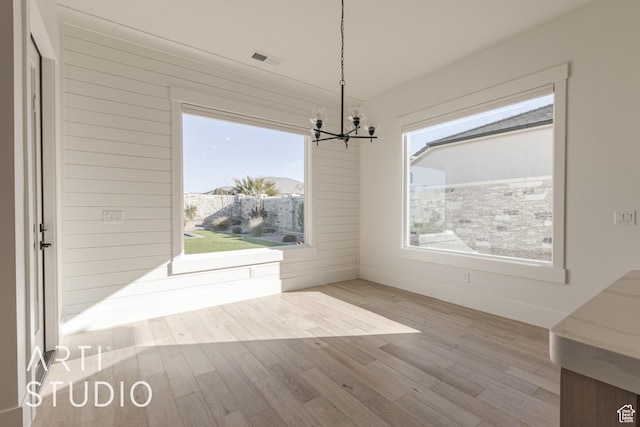 3783 S Kennedy Ln, Washington, UT 84780 - unfurnished dining area with a wealth of natural light, light wood-type flooring, and an inviting chandelier