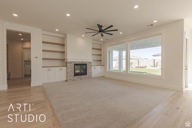 3783 S Kennedy Ln, Washington, UT 84780 - unfurnished living room featuring ceiling fan, light hardwood / wood-style flooring, and a stone fireplace