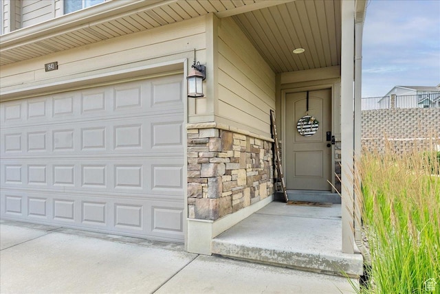 1841 E Whitetail Dr, Layton, UT 84040 - view of exterior entry featuring stone siding and a garage