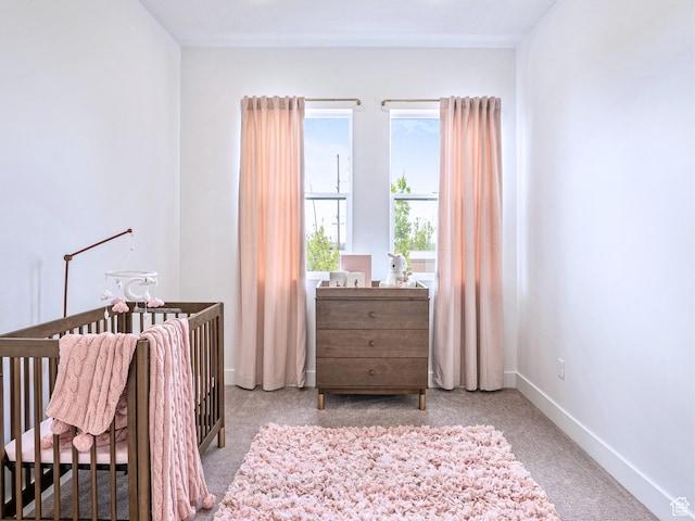 bedroom featuring baseboards, carpet flooring, and a nursery area