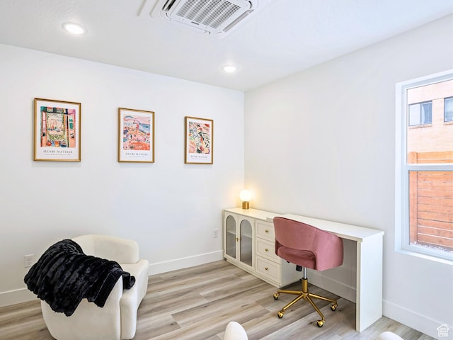 office area with baseboards, light wood-style floors, and visible vents