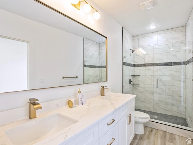 full bath with double vanity, toilet, a stall shower, and a sink